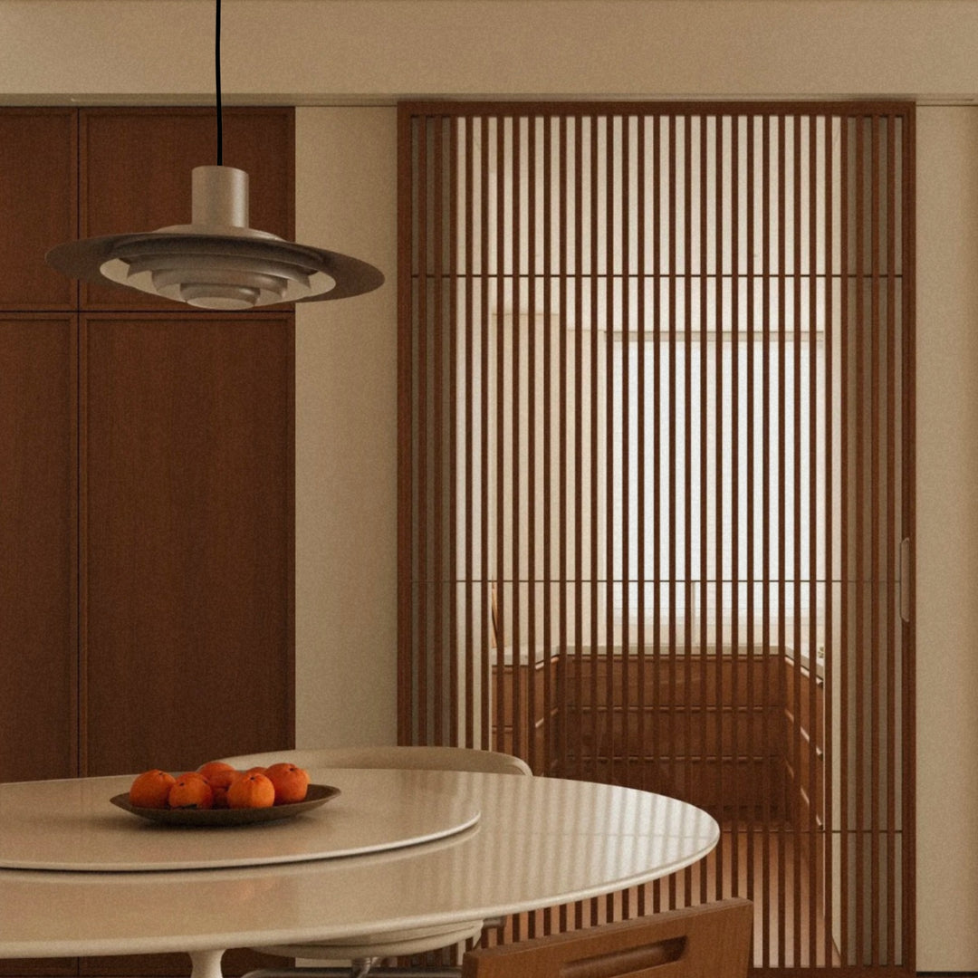 aluminium pendant light suspended above a dining table with a clean metal finish.