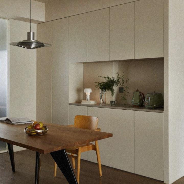 aluminum ceiling lamp centered above a kitchen table in a minimal layout.