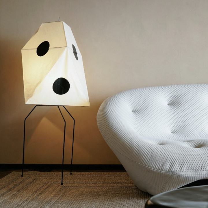 Handcrafted with cotton paper, this artistic floor lamp brings a soft glow to a minimalist living space.