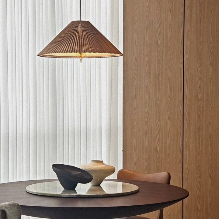 bamboo pendant lamp hanging above a round dining table in a calm contemporary interior.
