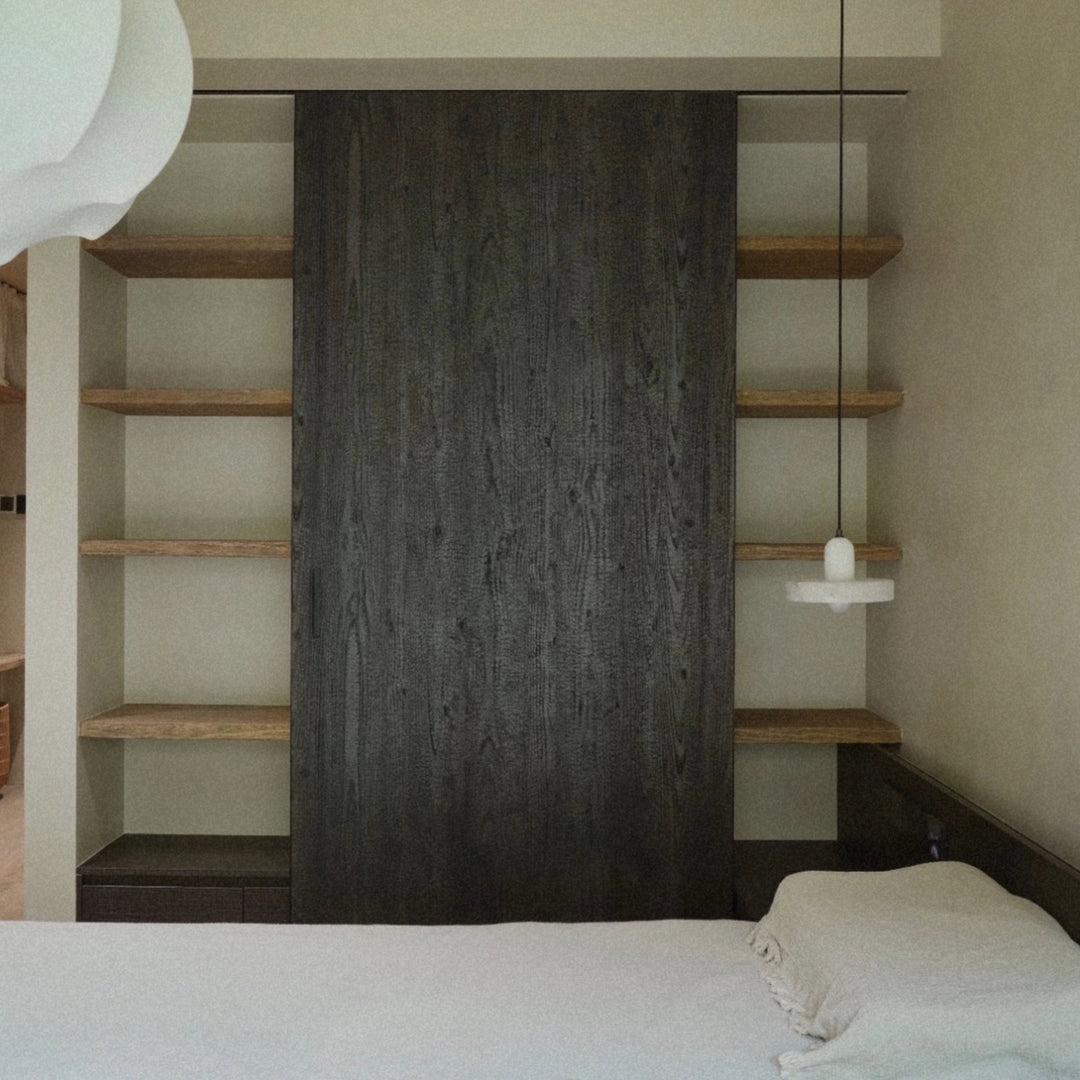 pendant light used as bedroom lighting beside a bed and open shelving.