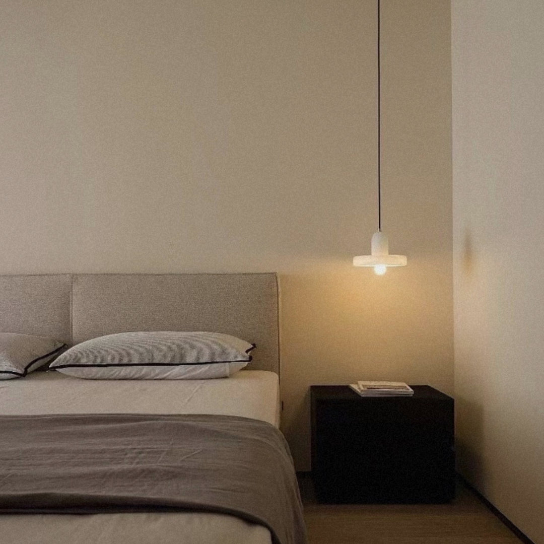 bedside pendant light hanging above a nightstand in a calm modern bedroom.
