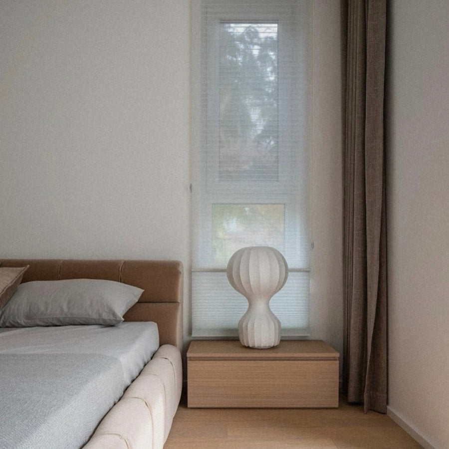 table lamp placed on a bedside unit adding soft light to a quiet bedroom.