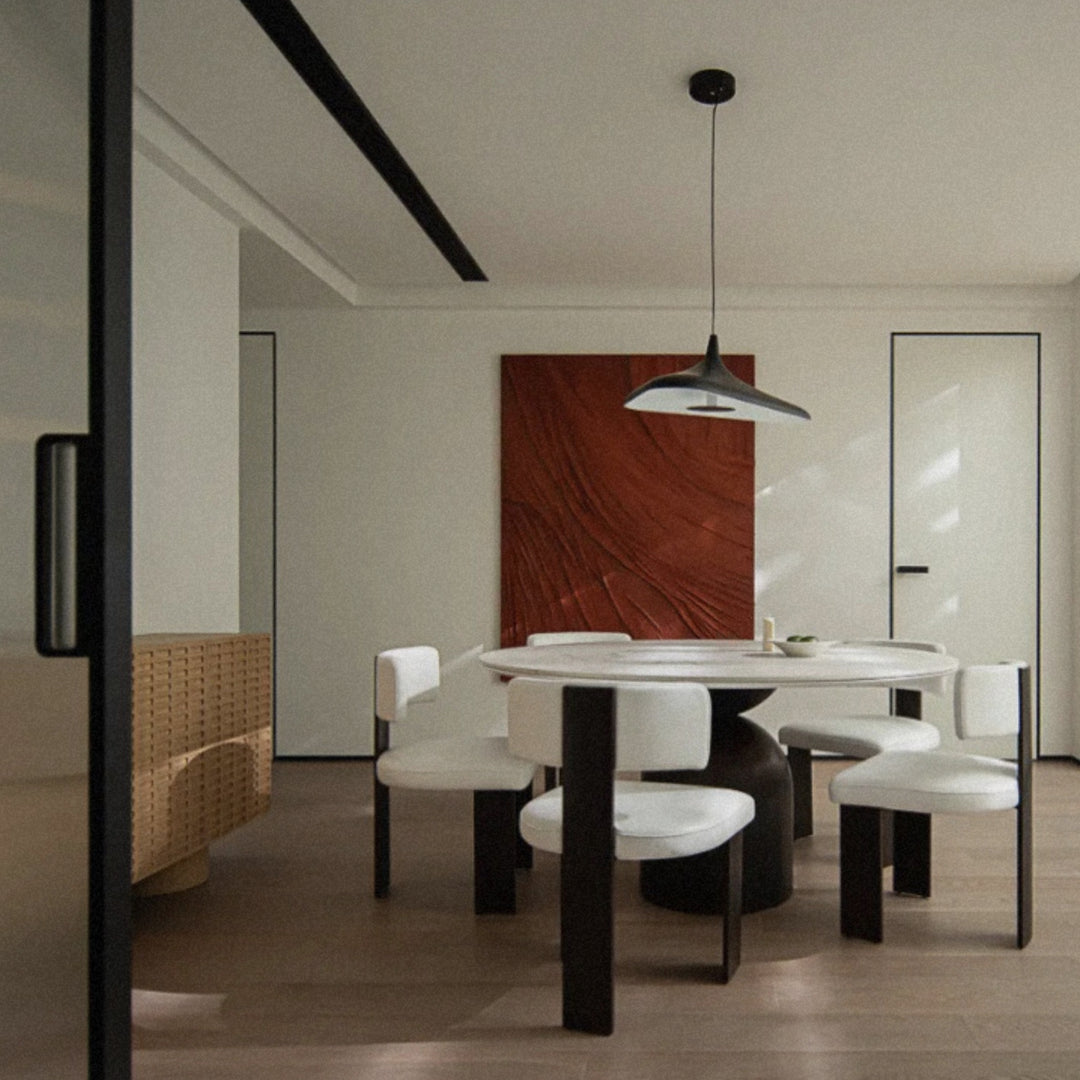 black designer pendant light centered above a round dining table in a contemporary dining room.