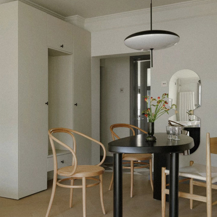 ceiling pendant light positioned over a dining setup in a contemporary room.