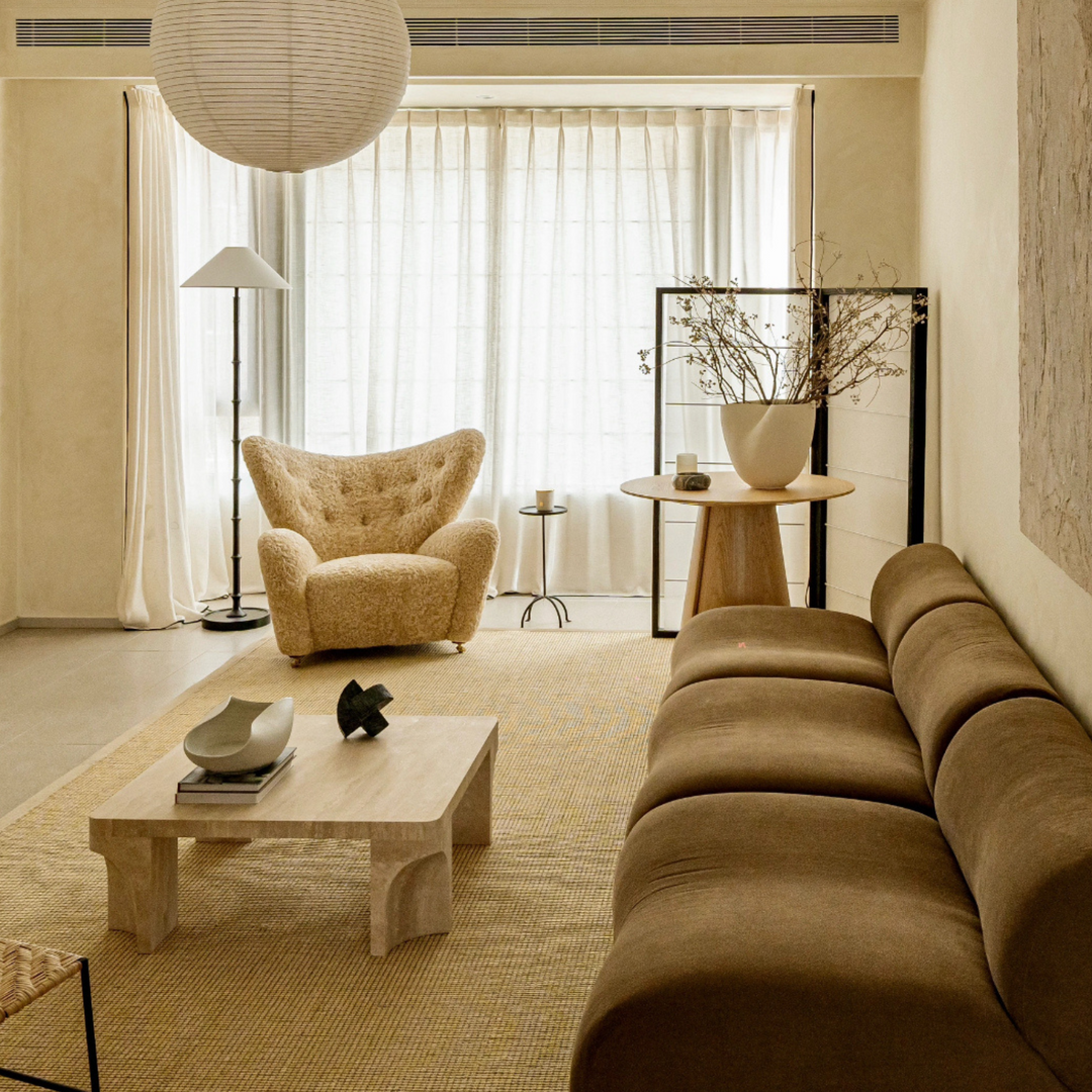 Handmade ceramic bowl displayed on a textured travertine coffee table in a warm and inviting living space.