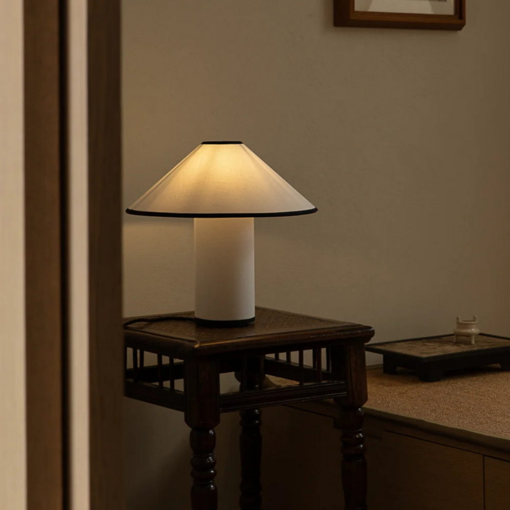 Classic bedroom setting with a table lamp providing warm lighting, perfect for timeless interior design.