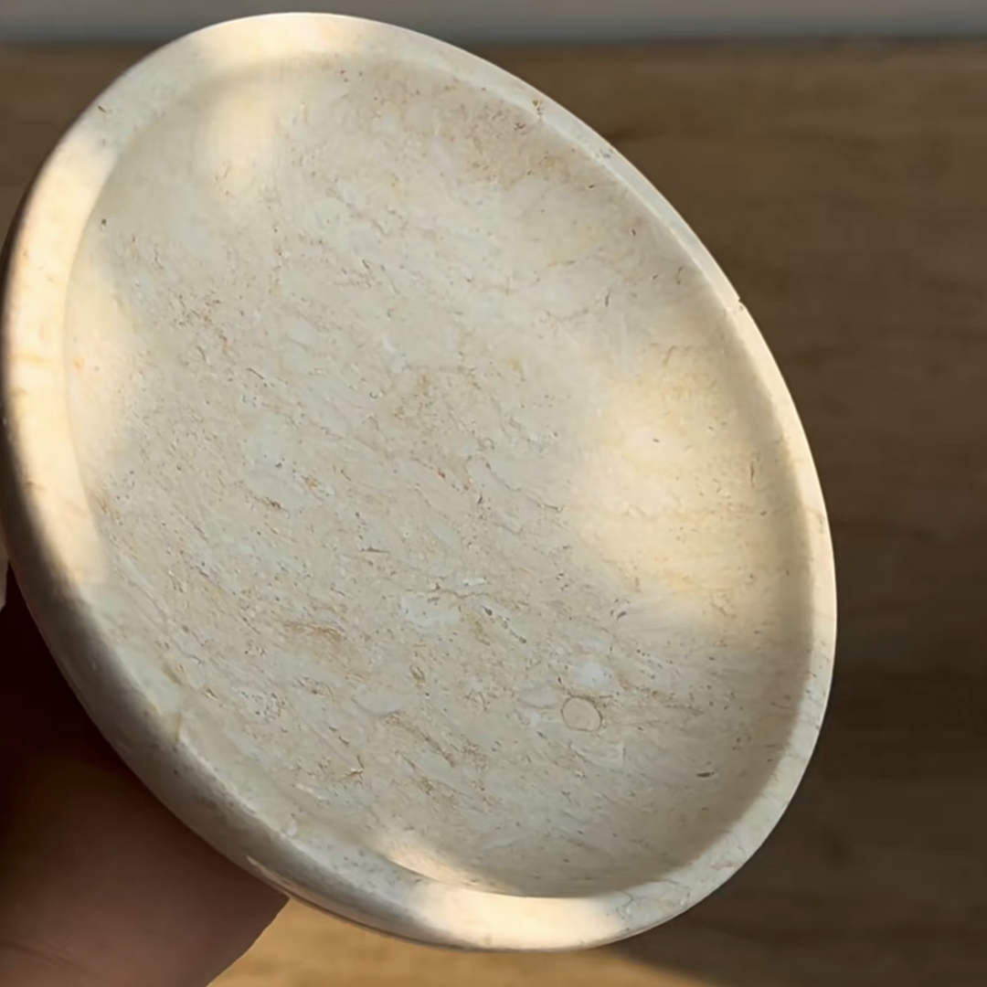 Close-up of a travertine bowl showcasing smooth, sculptural design.