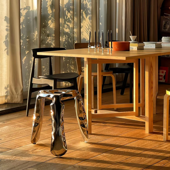 Sleek chrome stool enhancing a contemporary dining room with natural light.