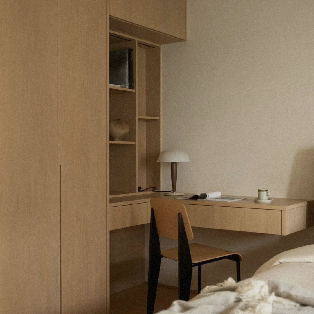 in a warm modern workspace a walnut wood table lamp adds soft illumination to the desk.