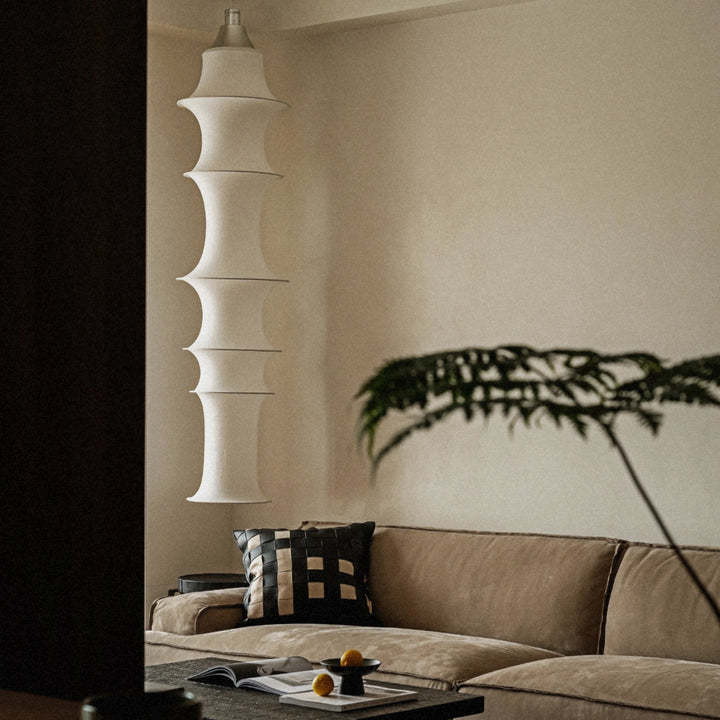 contemporary fabric pendant light hanging in a living room providing warm ambient illumination.