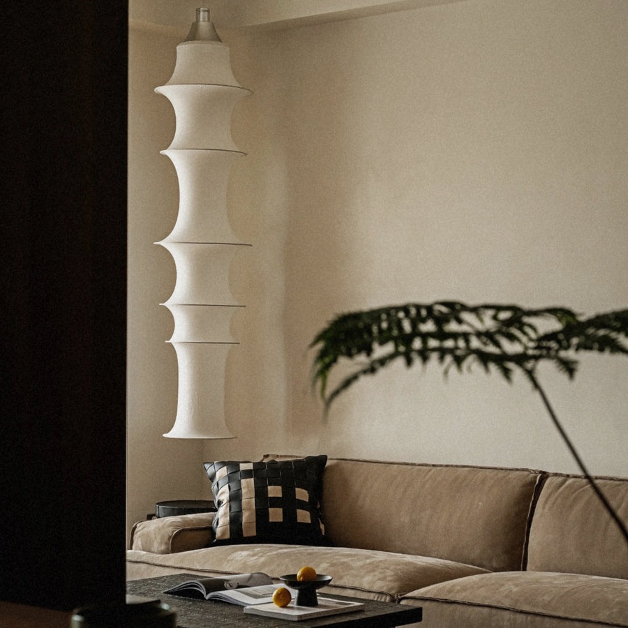 contemporary fabric pendant light hanging in a living room providing warm ambient illumination.