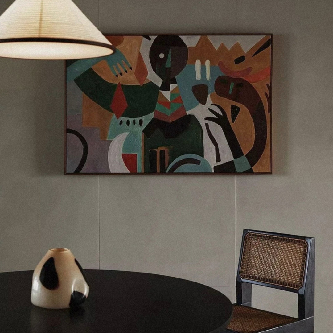 a contemporary glass vase displayed on a round table beside a chair and colorful wall art.