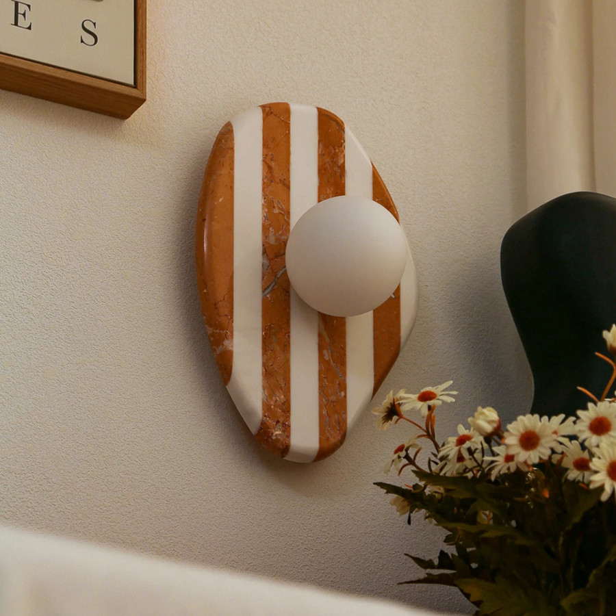 ontemporary marble wall sconce with a striped design and a central globe light, perfect for stylish interiors.