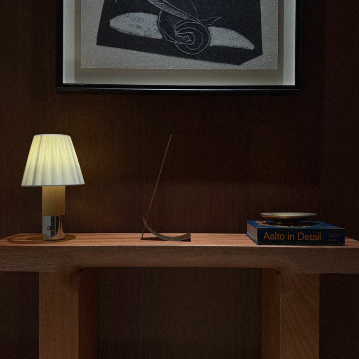 cordless table lamp used as a small bedside light on a shelf.