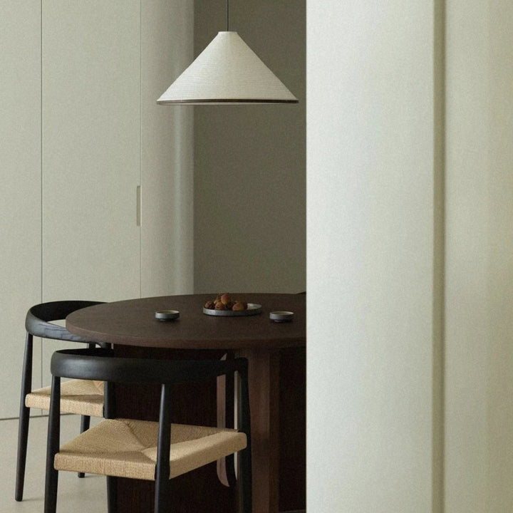cotton paper pendant light placed above a small dining setup.