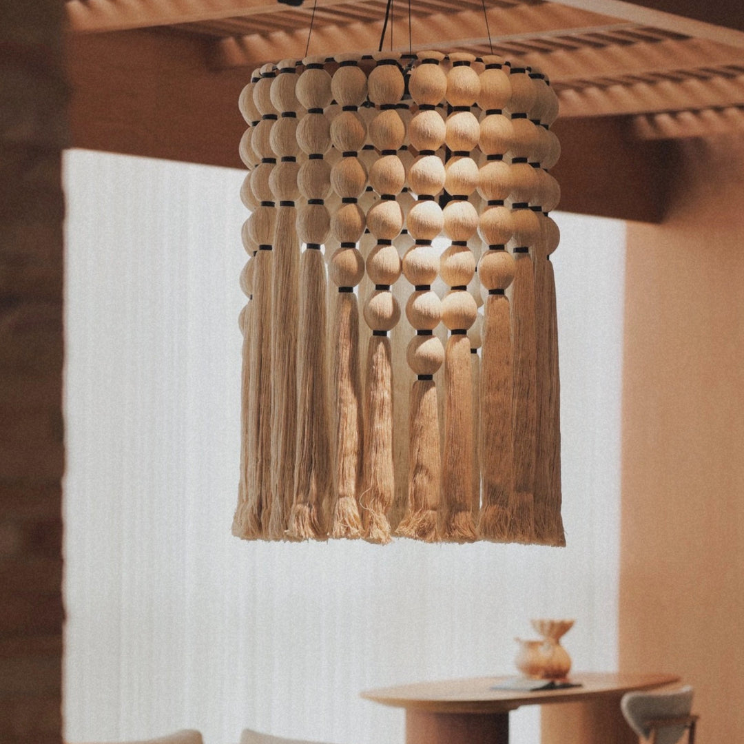 cotton thread tassel pendant light hanging from the ceiling creating warm ambient lighting in a natural interior.
