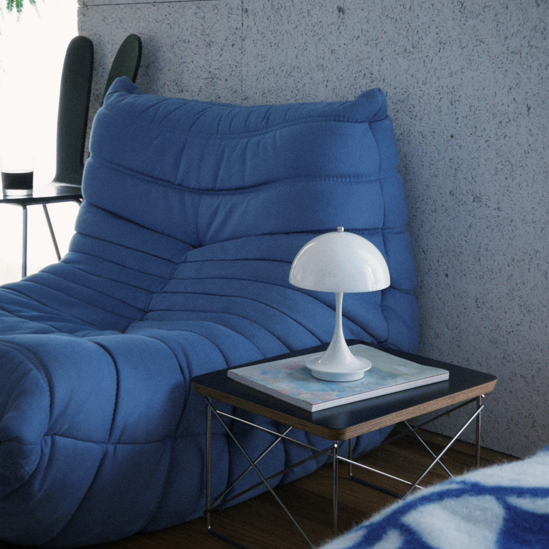 Cozy reading corner with a modern, cordless table lamp, offering an inviting space to unwind with soft lighting.