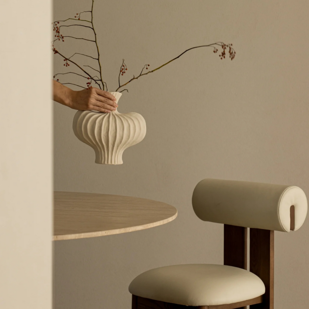 Cream ceramic sculptural vase with organic shape, perfect for minimalist and modern decor.