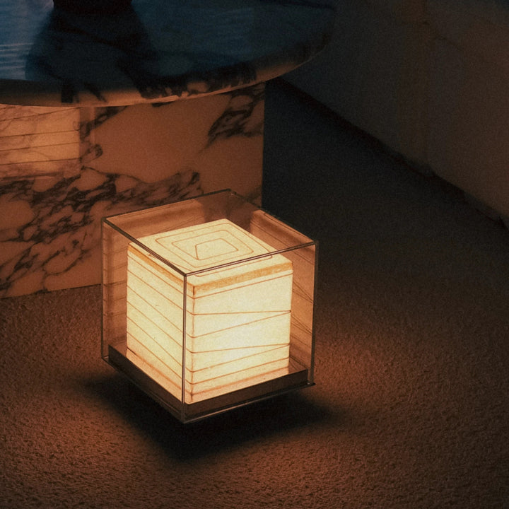 cube lamp glowing in a dark setting providing soft ambient lighting.