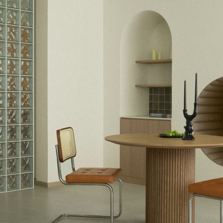 decorative ceramic candle holder positioned on a dining table in a calm contemporary space.