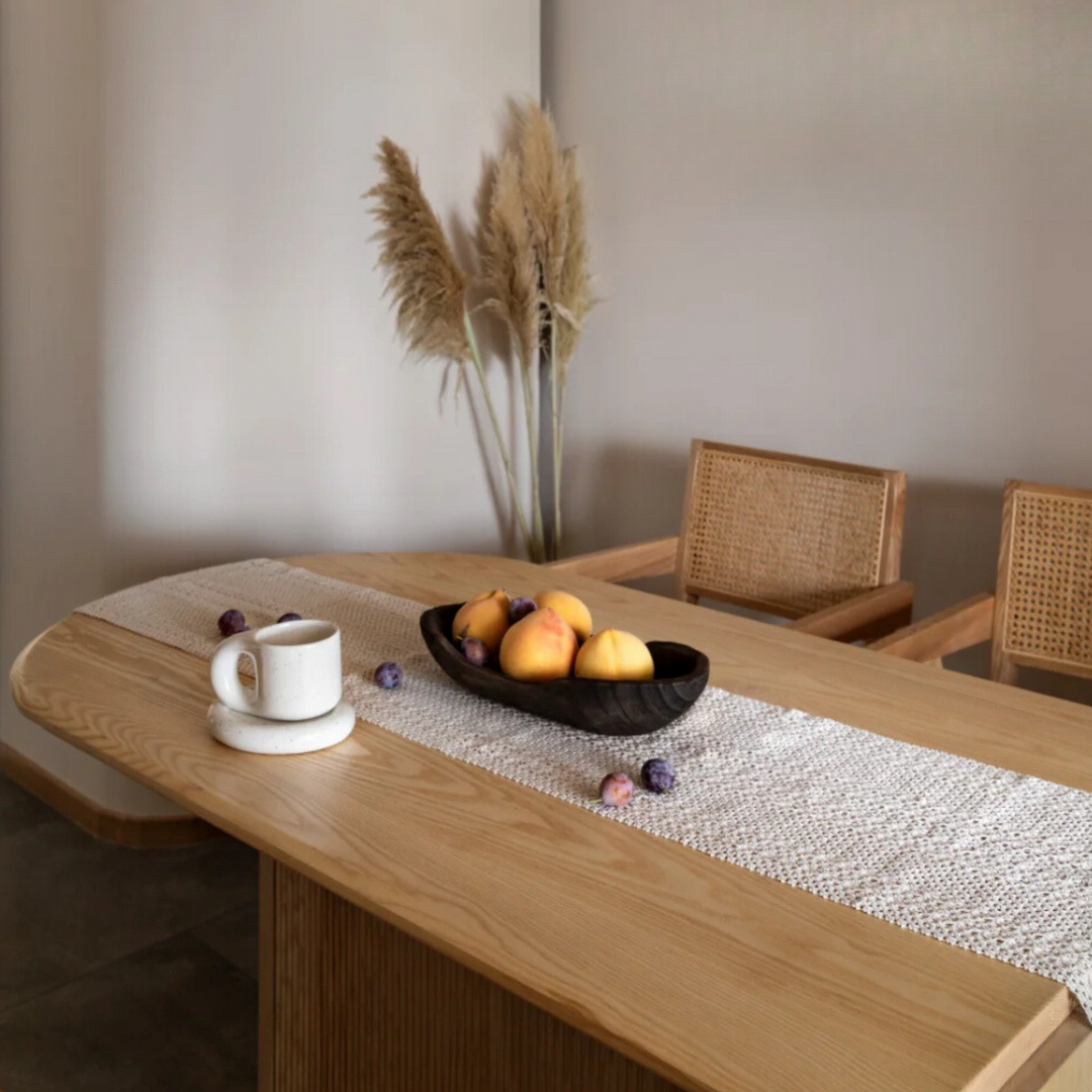 Decorative chunky ceramic mug and plate set on a wooden dining table with a cozy, minimalist setting.