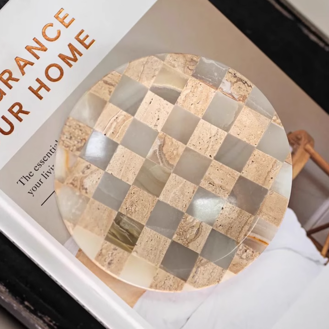 Decorative checkerboard tray with jade marble and travertine displayed on a book, adding elegance to the decor.