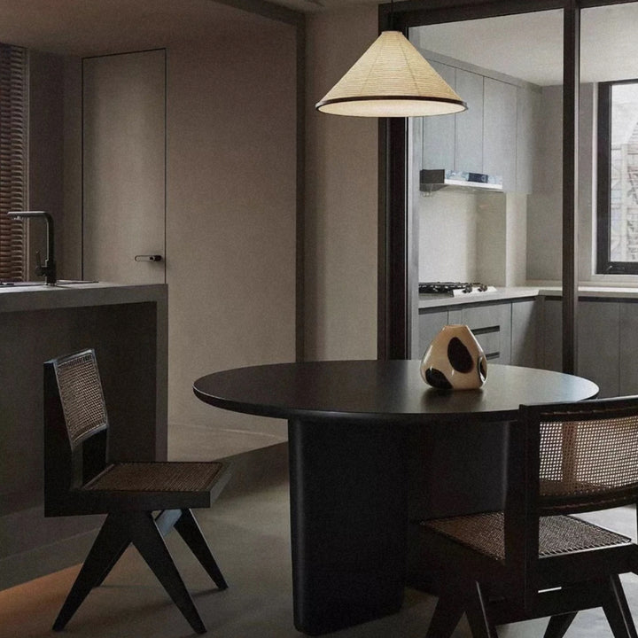 on a dark dining table a sculptural glass vase adds a simple decorative touch.