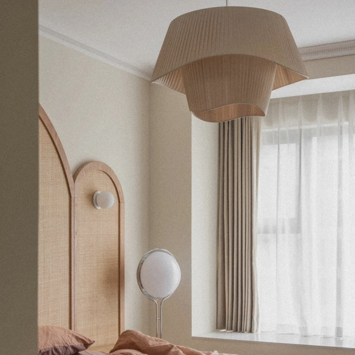 decorative pleated pendant light suspended near a bedroom window adding soft ambient lighting.