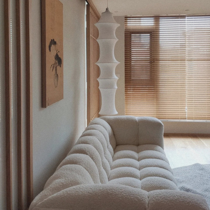 designer hanging pendant light placed above a sofa area in a contemporary living room.