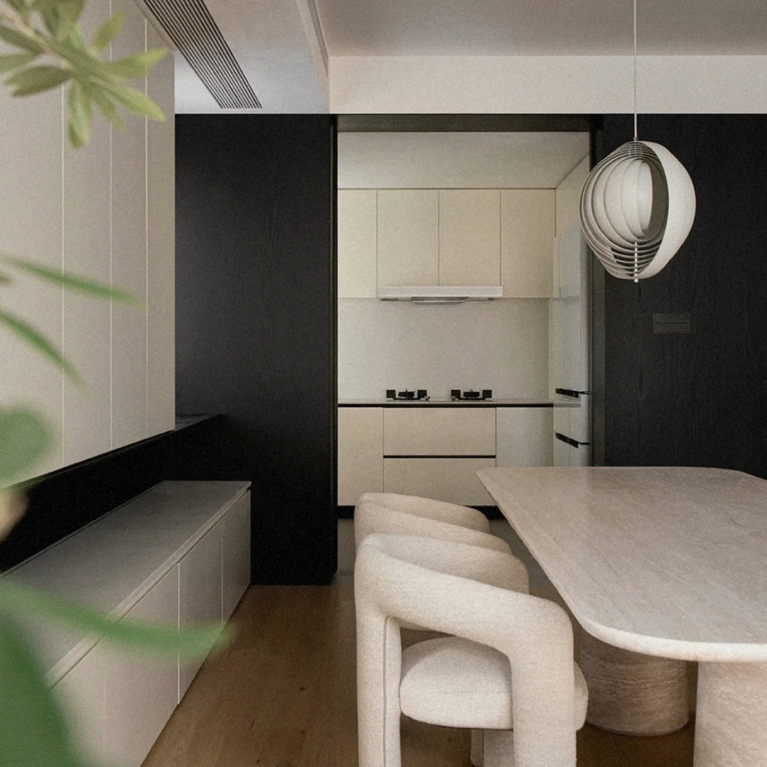 pendant light positioned over a dining table in a clean kitchen space.