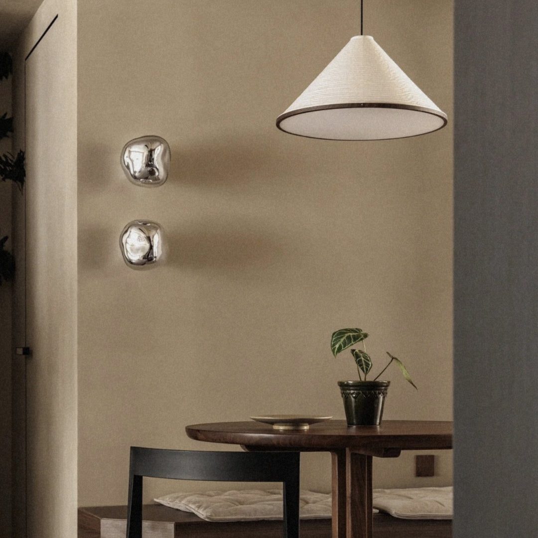 pendant light above a dining table creating soft ambient lighting.
