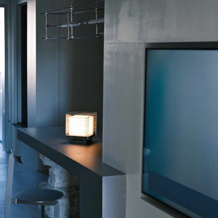 Sculptural table lamp on modern console styled next to TV and hanging fixture