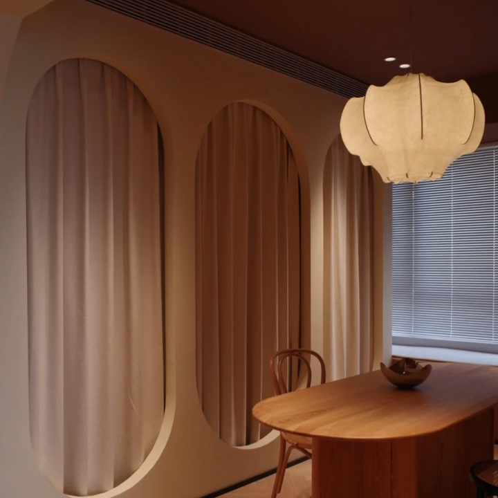 Elegant light fixture in a modern dining room, offering a soft glow that enhances the wooden furniture and sophisticated decor.