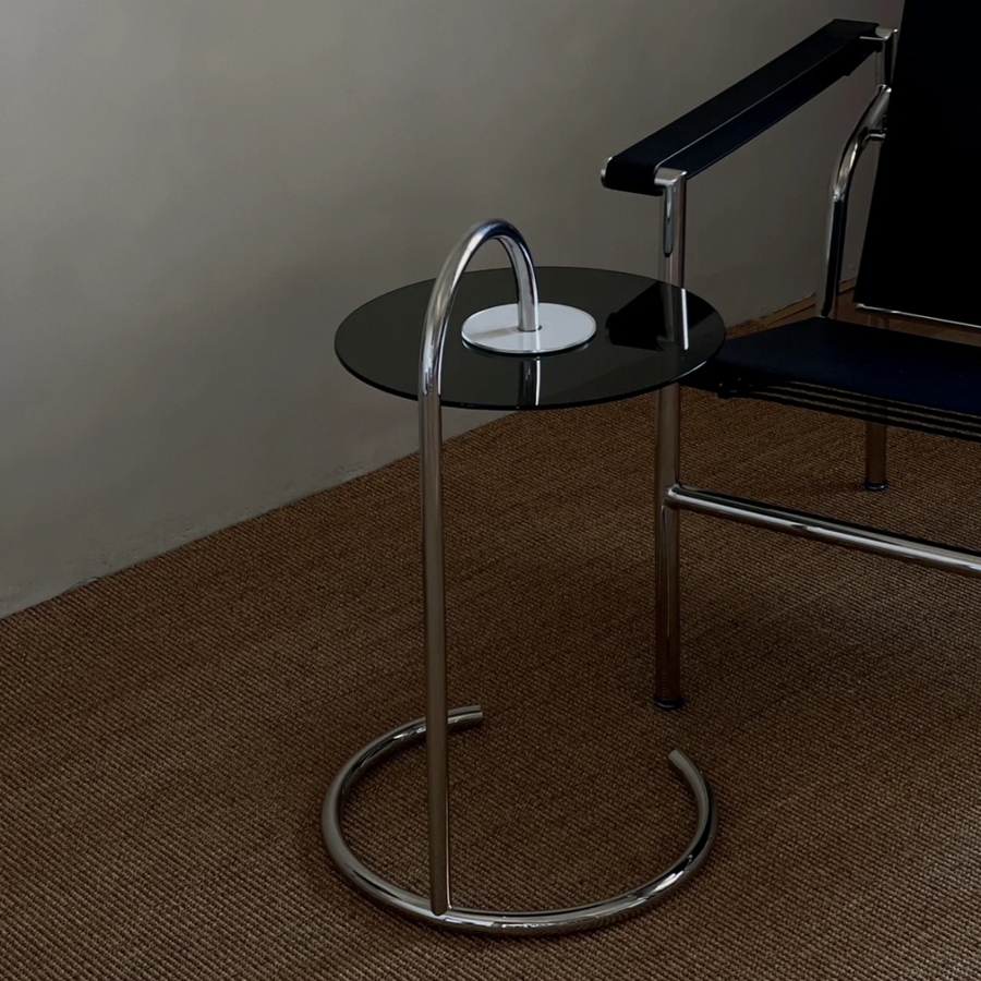 Elegant glass coffee table with a chrome base in a modern interior, featuring a clear glass top and minimalist design, perfect for contemporary living spaces.