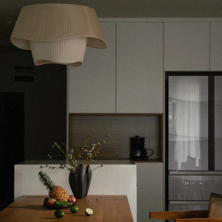 fabric ceiling pendant light hanging above a dining table in a contemporary kitchen dining space.