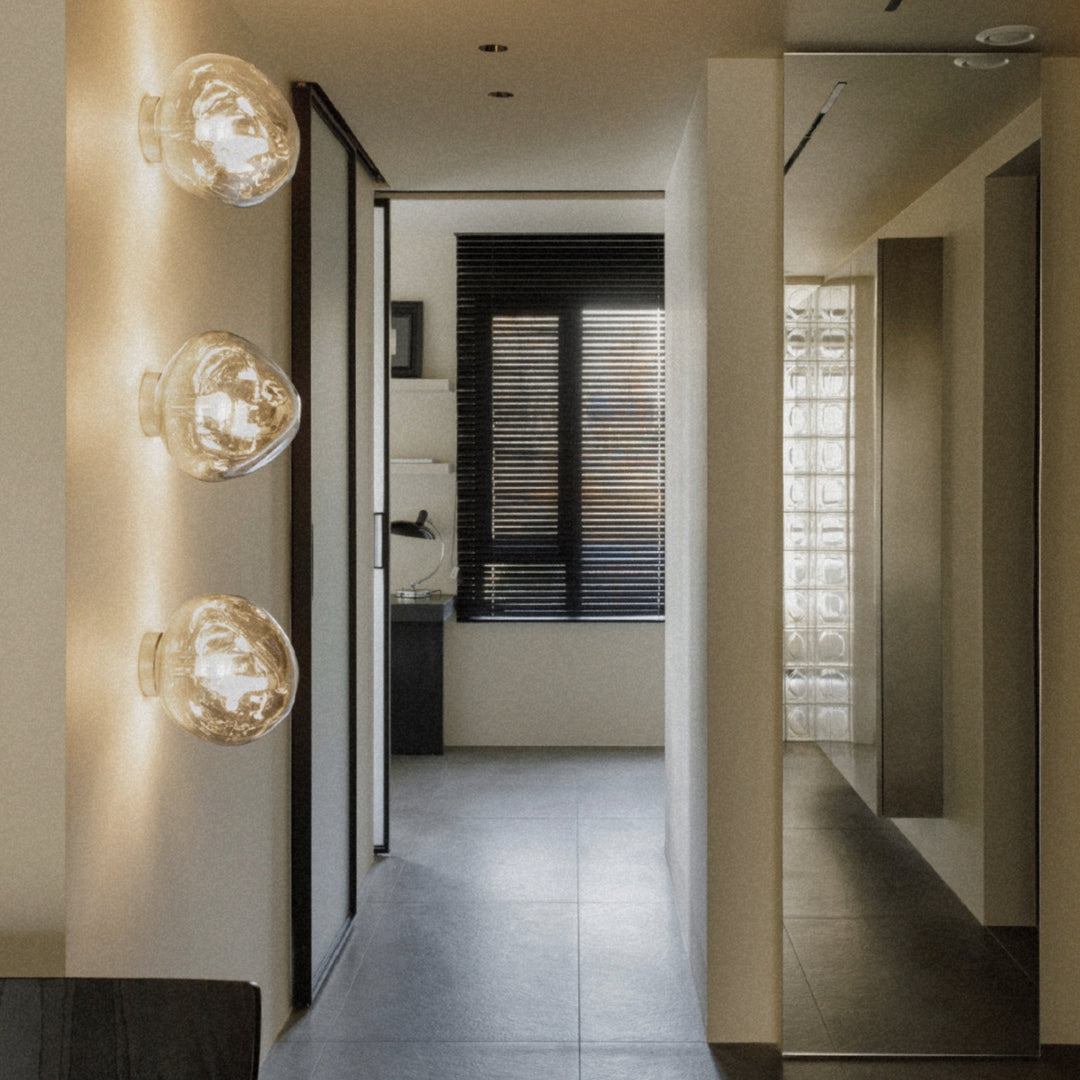 glass wall lamp illuminating a narrow hallway with a clean modern look.