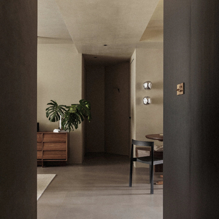 glass wall sconce installed along a hallway creating soft ambient lighting.