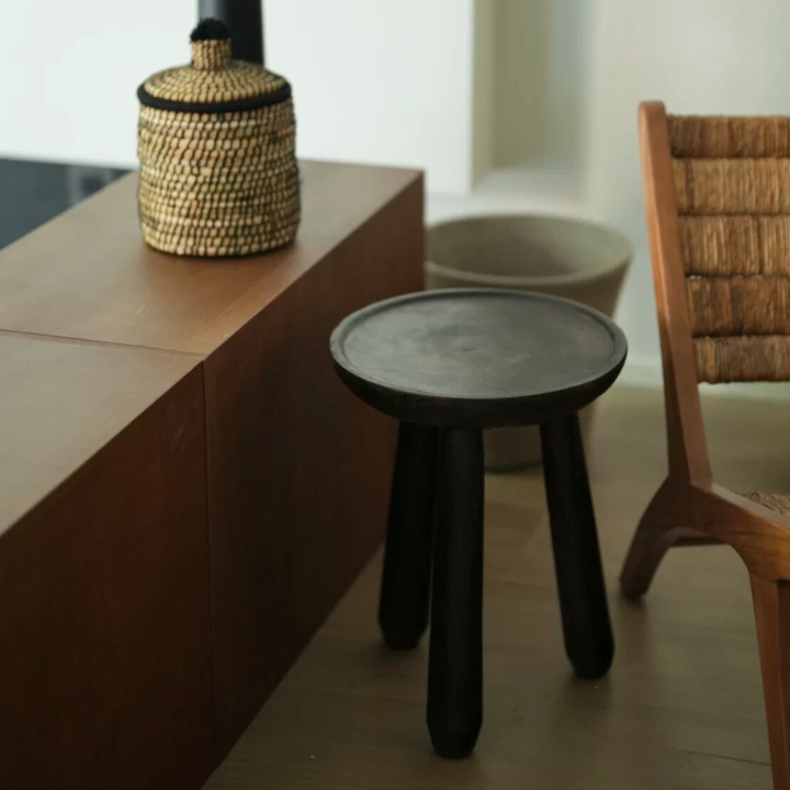 Hand-carved wooden side table showcasing its organic design and unique imperfections.