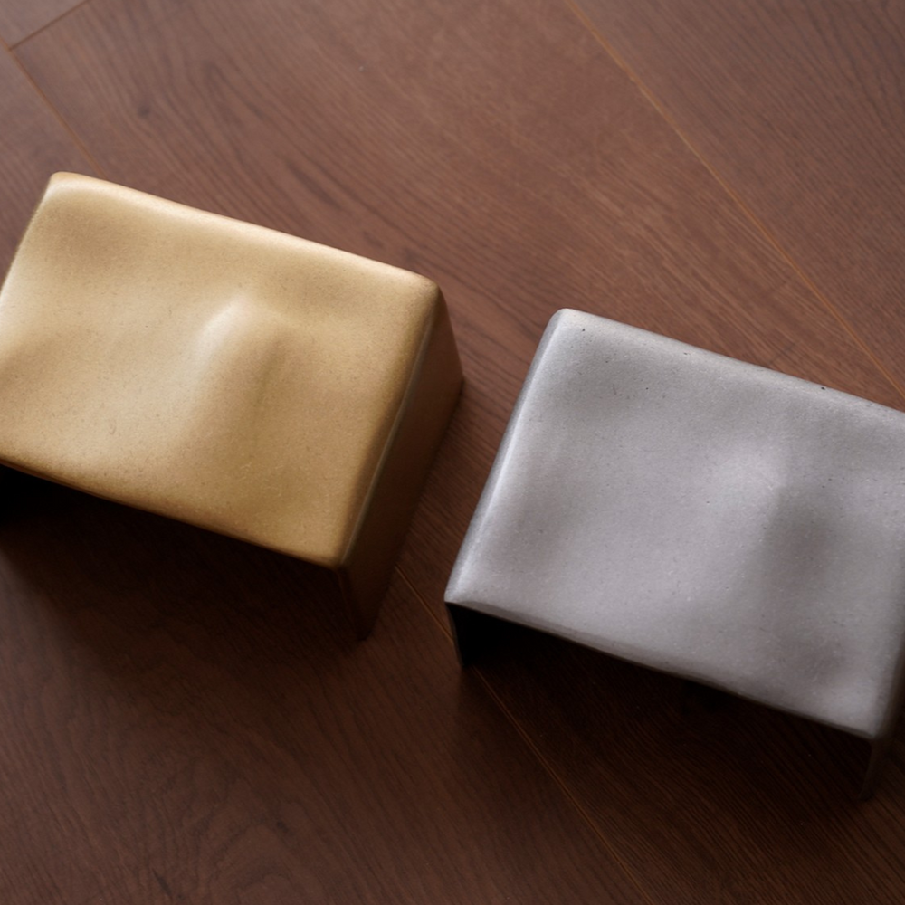 Handcrafted brass and aluminum wall lights with a sculptural finish.