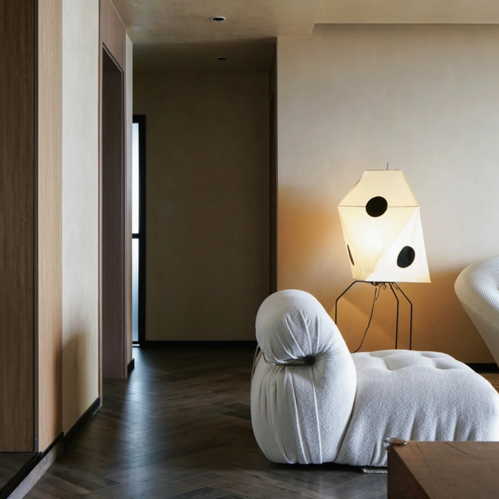 Featuring a sculptural design, this handmade floor lamp complements the neutral tones of a sophisticated living room.