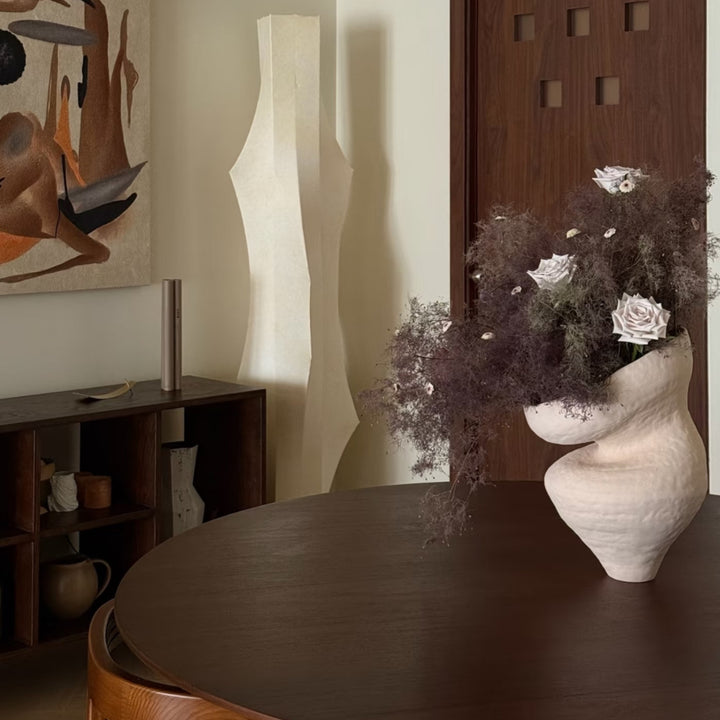 Japandi vase filled with soft white florals on wood table.