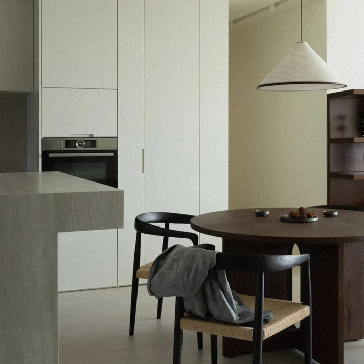 pendant light positioned over a dining table within a kitchen space.
