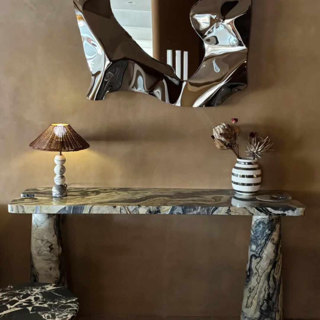 Rattan and marble lamp styled on a black console table, adding timeless elegance to the decor.