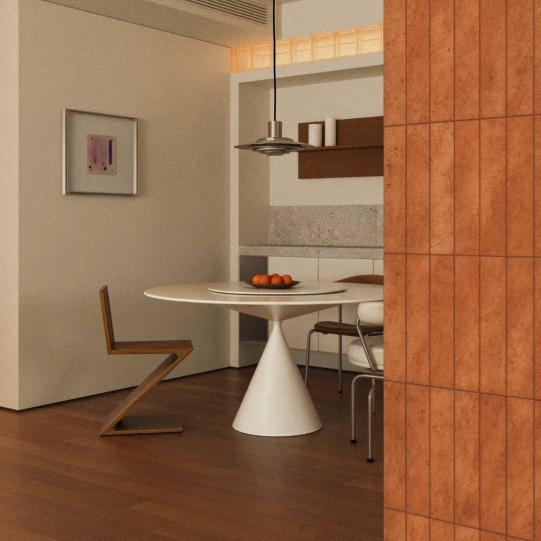 metal pendant lamp hanging over a round dining table in a warm interior.