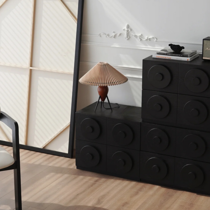 Mid-century lamp placed on a black storage cabinet against a modern backdrop.