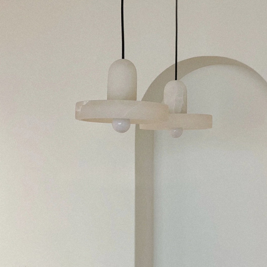 minimal pendant light with a clean sculptural form suspended from the ceiling.