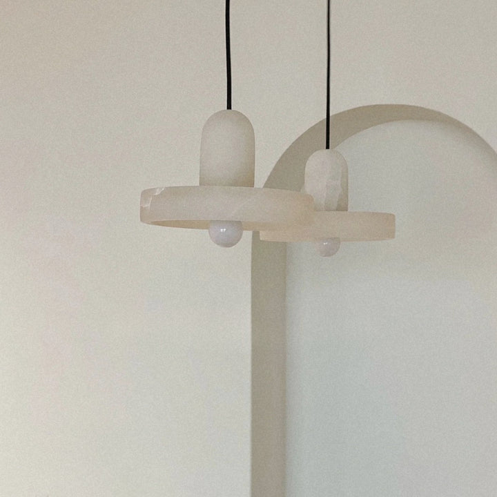 minimal pendant light with a clean sculptural form suspended from the ceiling.