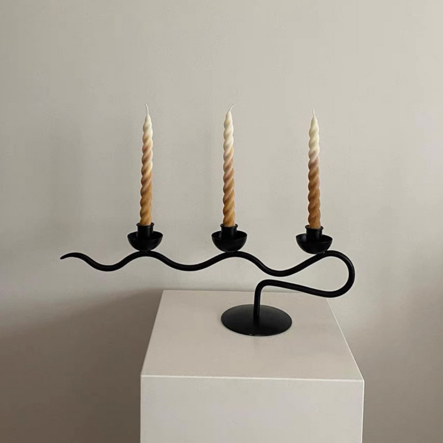 Minimalist black candle holder with twisted candles, perfect for modern home decor.