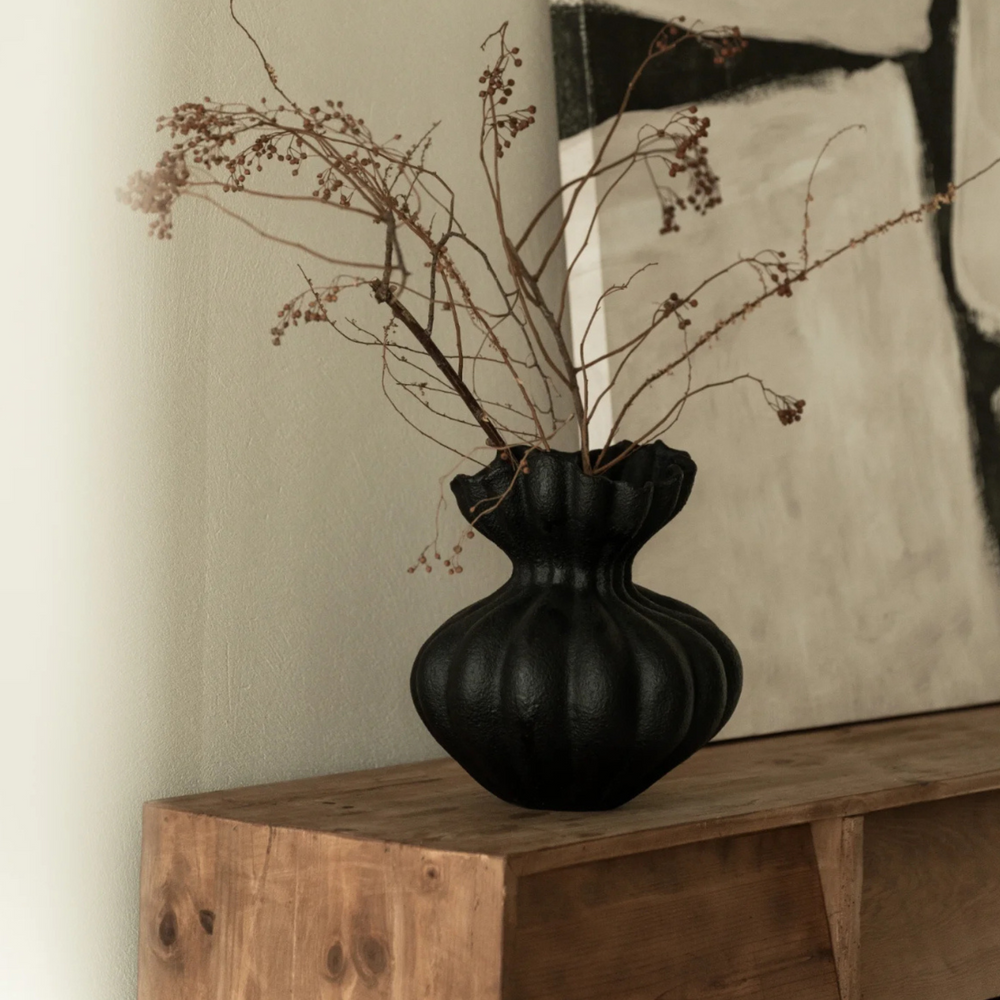 Sleek black vase on rustic wooden console table, enhancing a modern minimalist decor